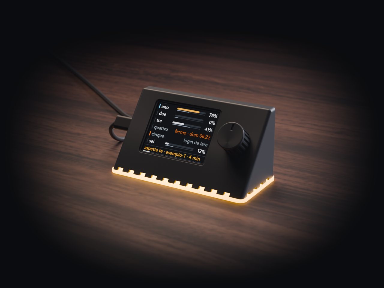 Render of test build 1 on a dark wooden desk: a wedge-shaped graphite shell with a screen and a knob, and an amber light under its pale base.